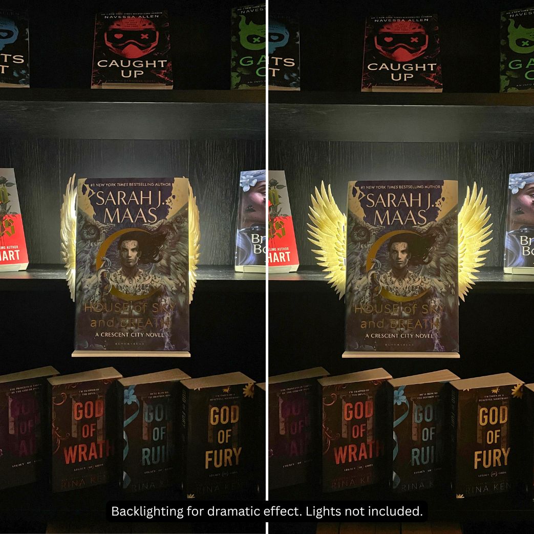 Side-by-side comparison of closed and open Curio Clip-On Angel Wings attached to a Curio Candy Floating Book Display Hanger, backlit on a dark romance bookshelf featuring Sarah J. Maas.