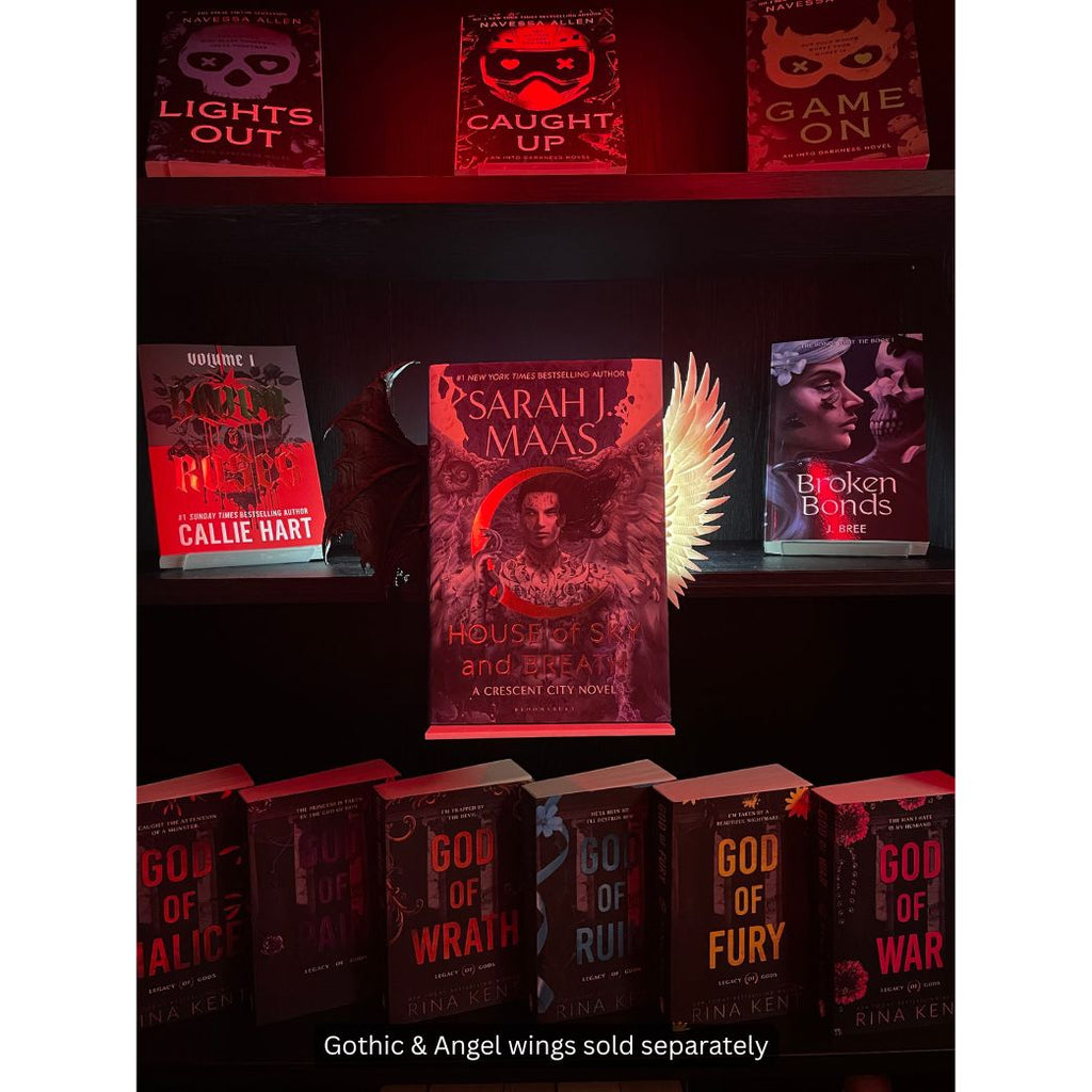 Curio Clip-On Gothic Demon Bat Wing and Angel Wing shown together on a Curio Candy Floating Book Display Hanger, styling Sarah J. Maas's House of Sky and Breath on a fantasy bookshelf.