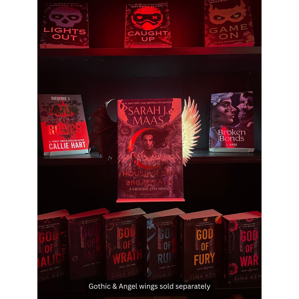 Curio Clip-On Gothic Demon Bat Wing and Angel Wing shown together on a Curio Candy Floating Book Display Hanger, styling Sarah J. Maas's House of Sky and Breath on a fantasy bookshelf.